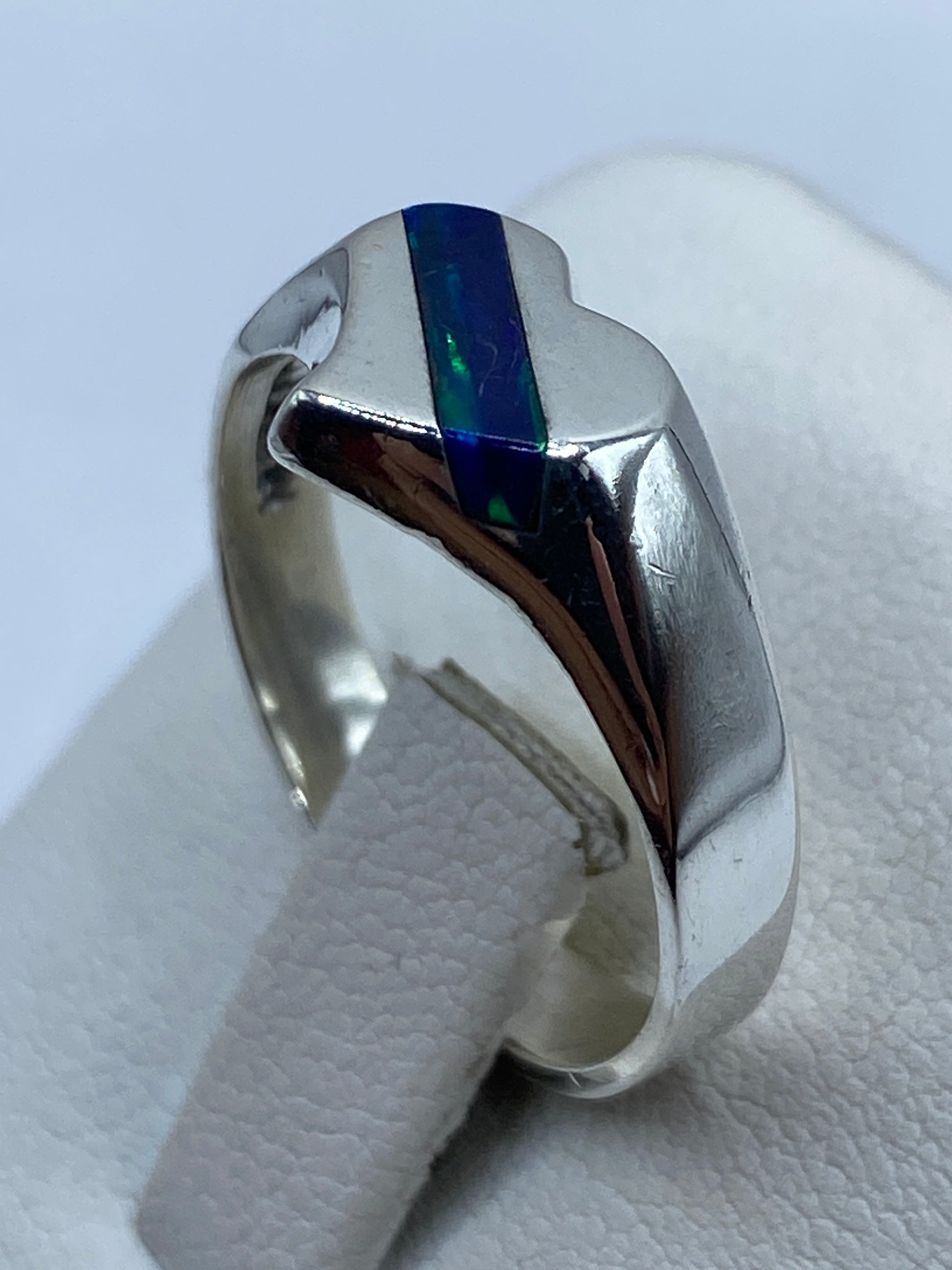 Detalle lateral del ópalo de fuego azul con vetas verdes engastado en plata