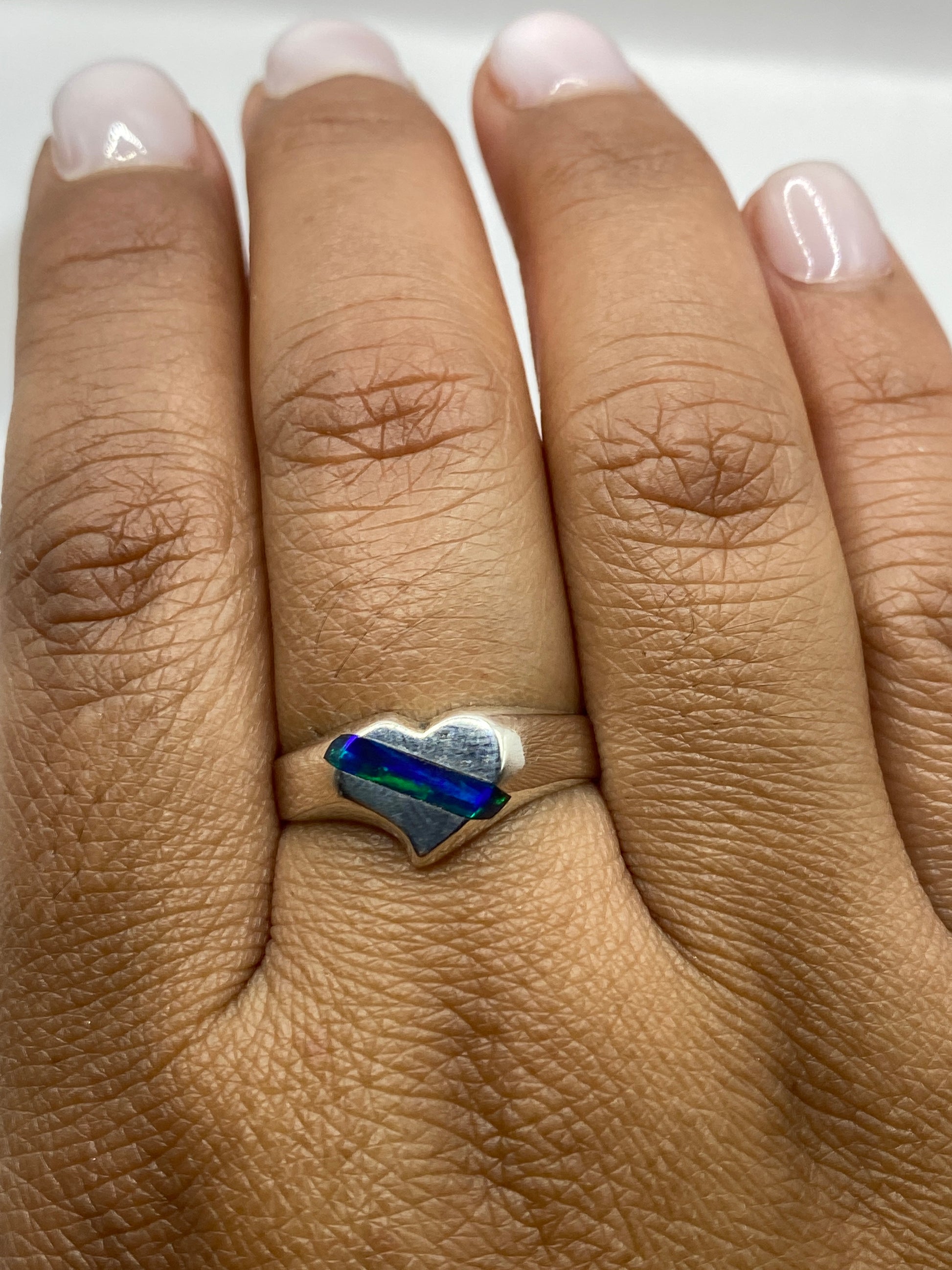 Anillo en dedo mostrando el brillo y color del ópalo de fuego con sello .950