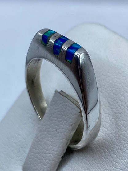Detalle lateral del engaste del ópalo de fuego azul en banda de plata bruñida