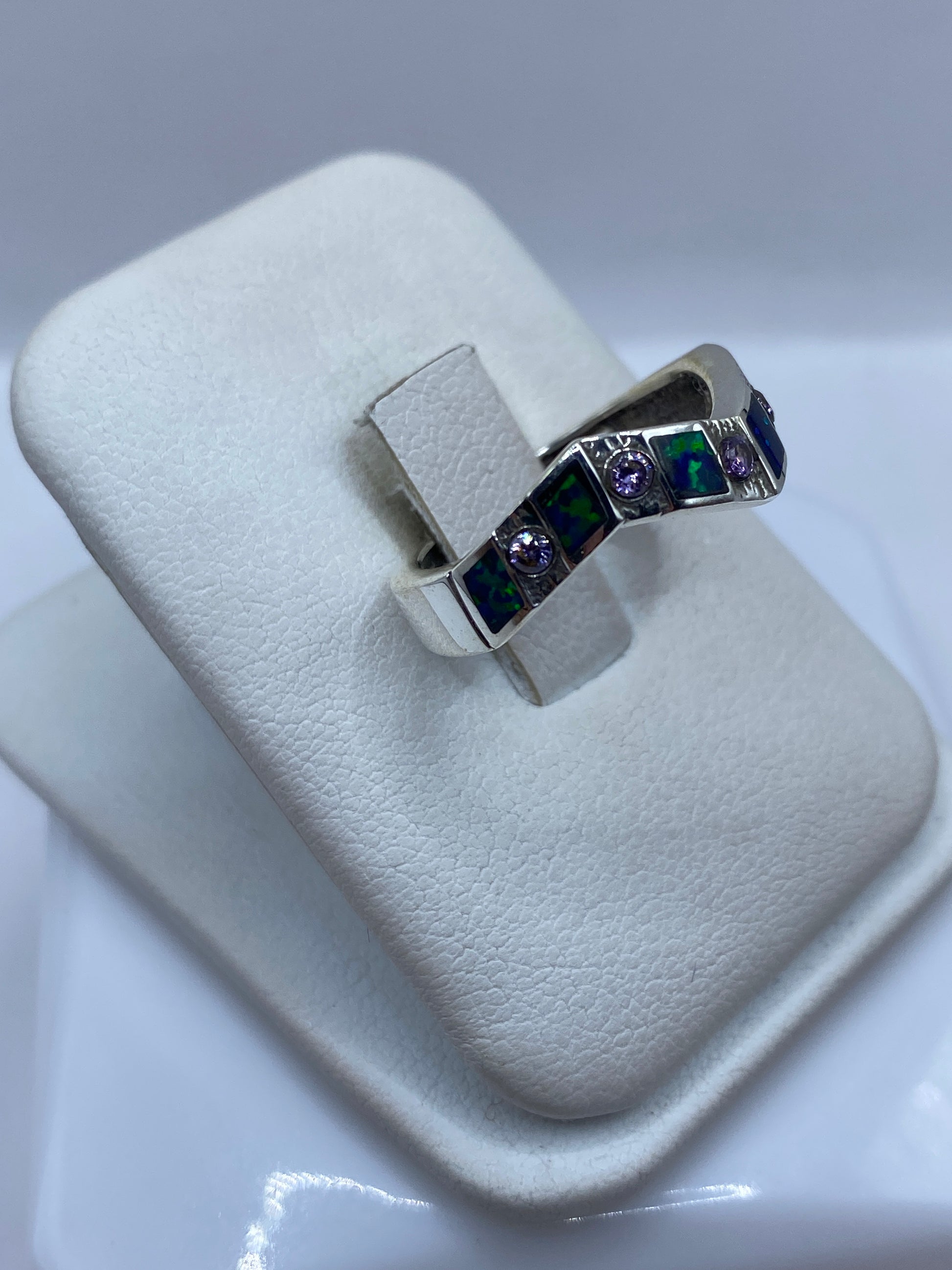 Detalle del ópalo de fuego natural con matices azul y verde en anillo de plata pura