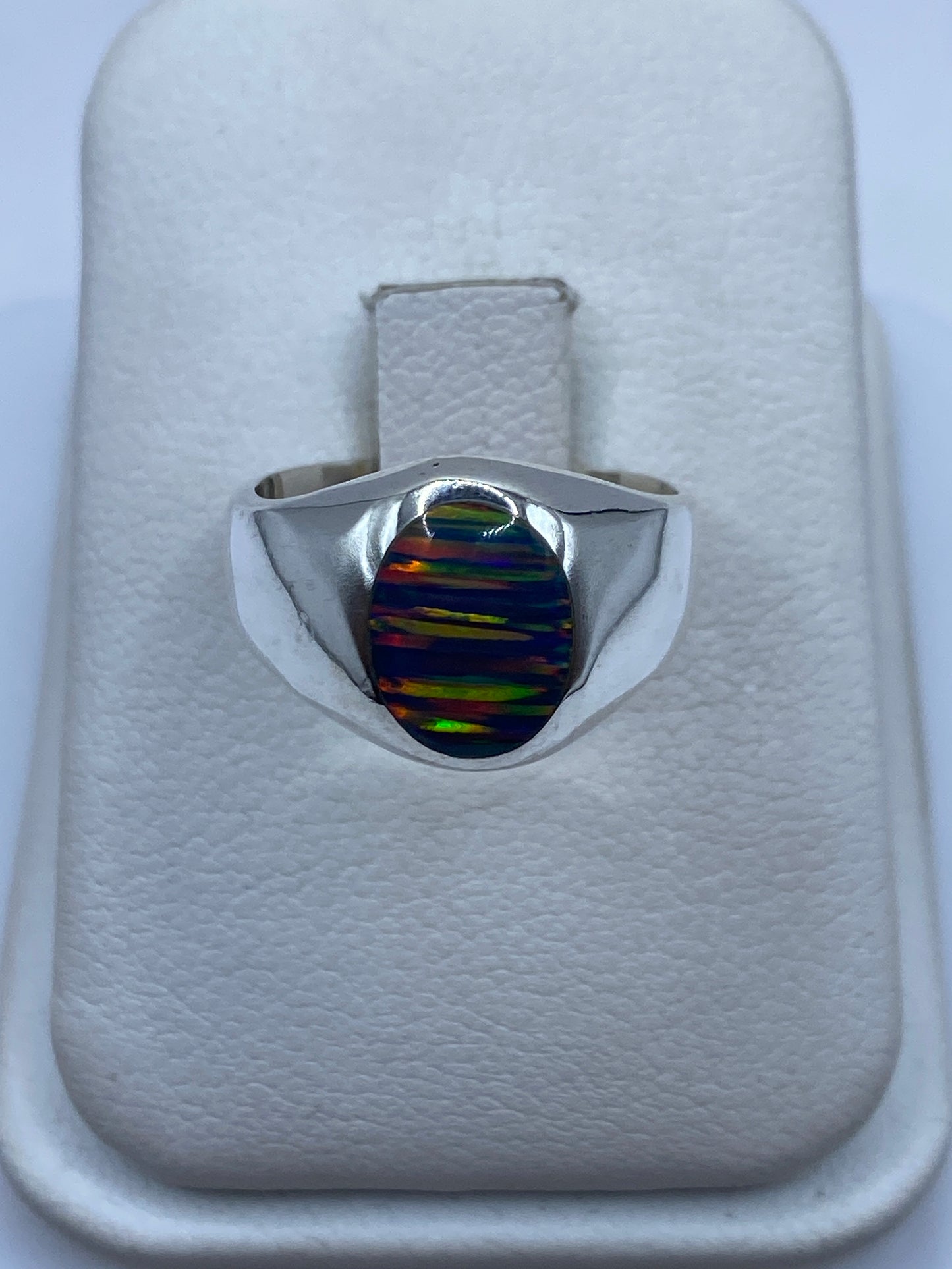 Anillo de plata .950 con ópalo de fuego multicolor mostrando juego de colores verde, naranja y azul