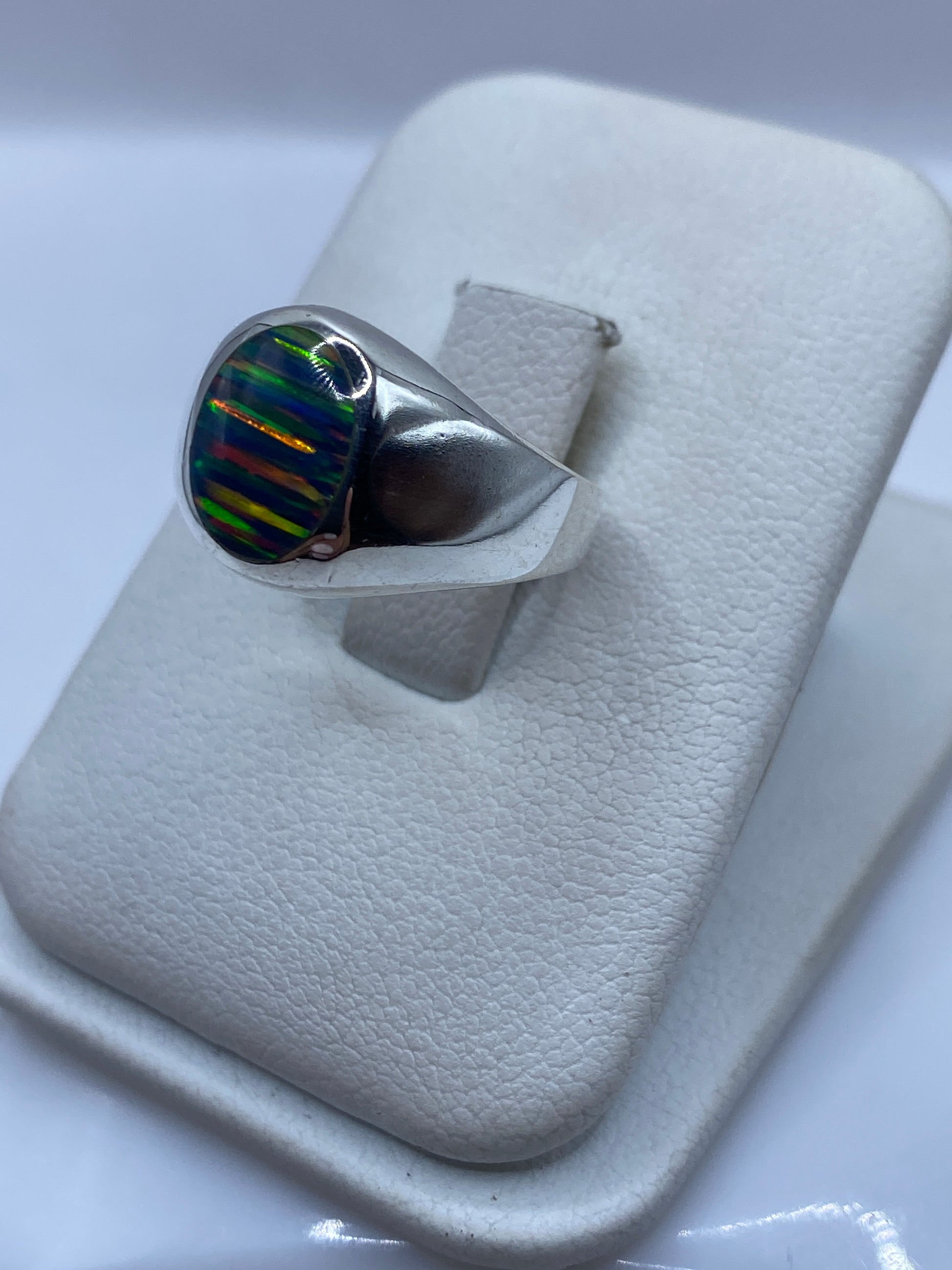 Vista lateral del anillo unisex en plata de Taxco con ópalo de fuego natural engastado