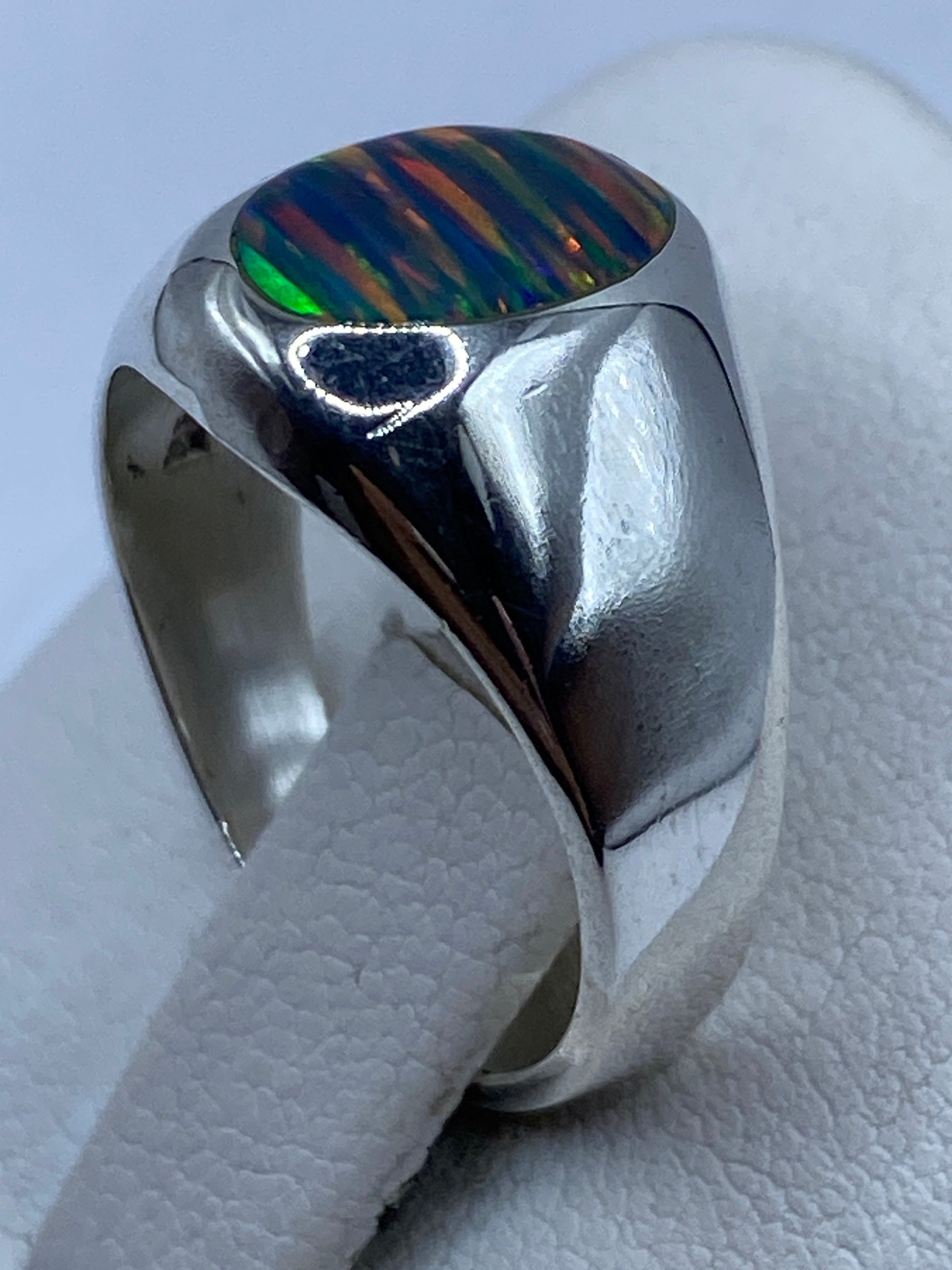 Detalle del ópalo multicolor en anillo de plata .950 capturando luz con fuego intenso