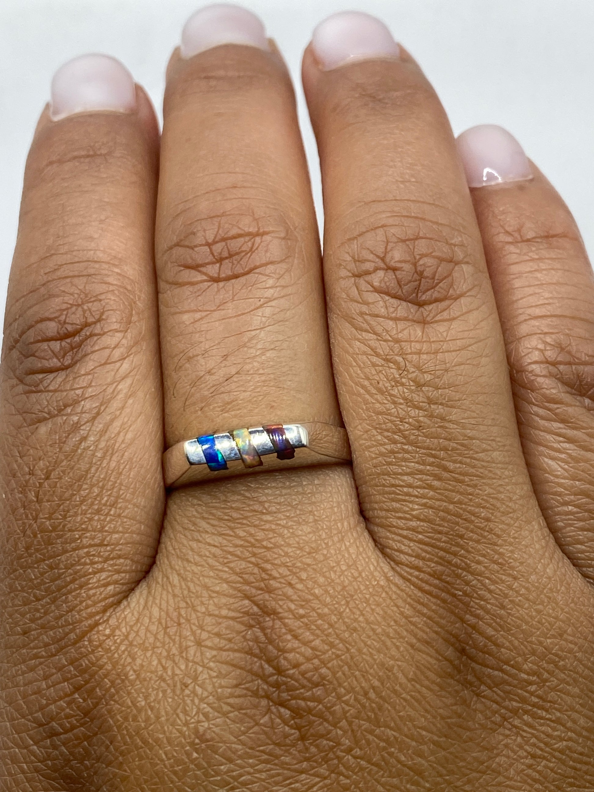 Anillo en dedo mostrando brillo y reflejos multicolores del ópalo de fuego