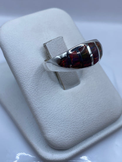 Vista lateral del anillo con bandas de plata que abrazan la piedra de ópalo