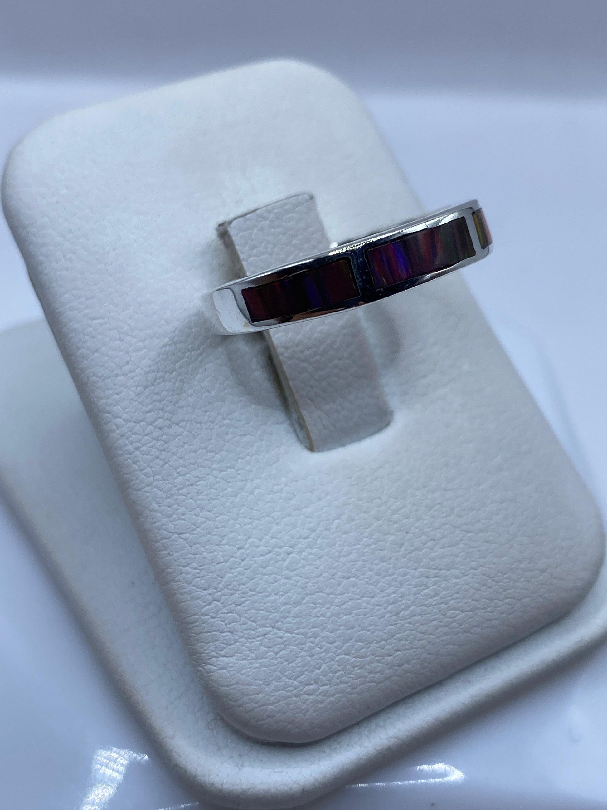 Anillo ópalo fuego desde el perfil, mostrando el tallado y el juego de colores rojos y naranjas