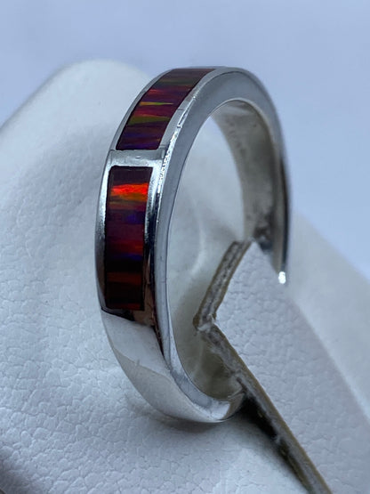 Ópalo multicolor del anillo en detalle lateral, luz natural revelando verde y rojo