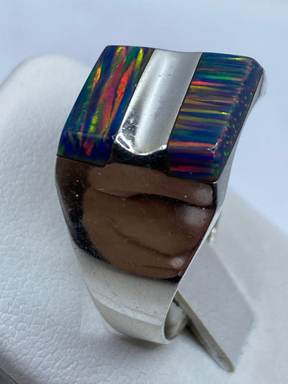 Anillo ópalo de fuego en la mano mostrando el juego de colores bajo luz natural