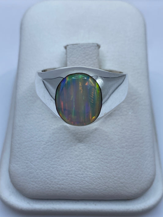 Anillo de plata solitario con ópalo de fuego multicolor mostrando juego de colores naranjas, verdes y azules