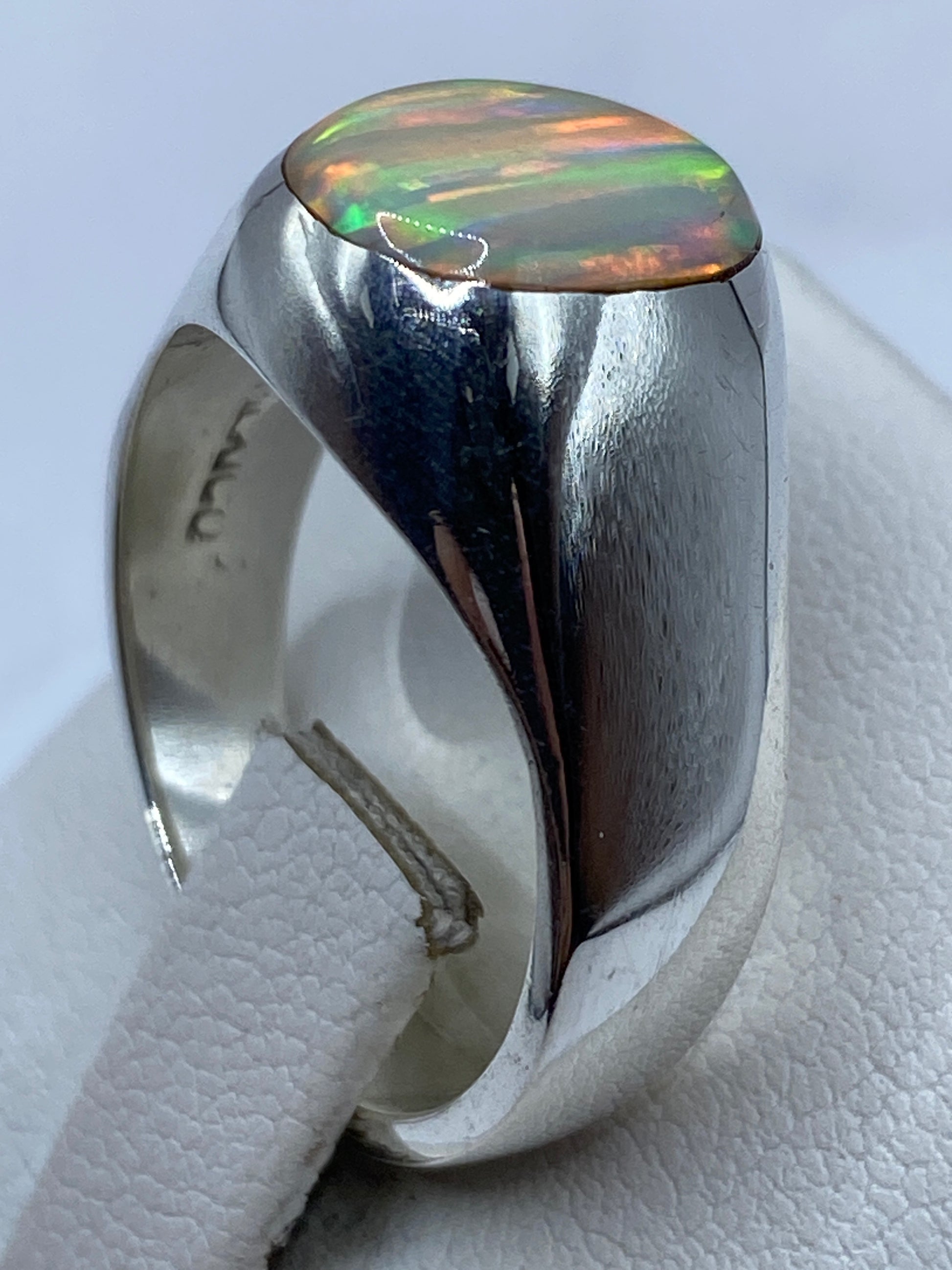 Detalle del ópalo natural engastado en plata, capturando el patrón de fuego único de la piedra