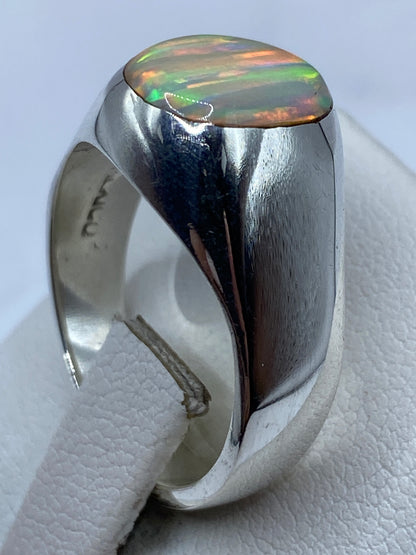 Detalle del ópalo natural engastado en plata, capturando el patrón de fuego único de la piedra