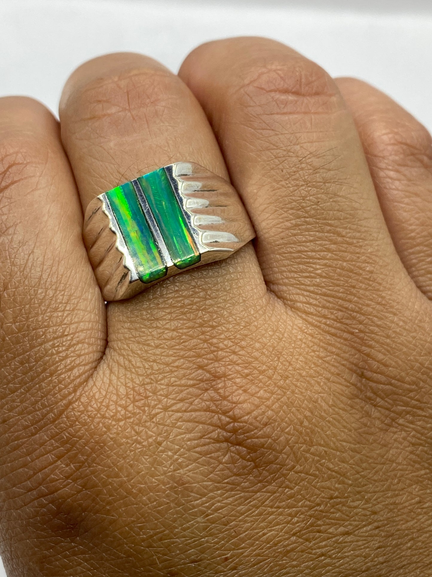 Anillo en dedo de hombre sobre fondo gris, mostrando proporción y presencia