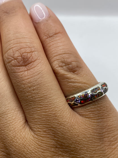 Anillo sobre fondo gris mostrando el sello 950 y la irradiación natural del ópalo