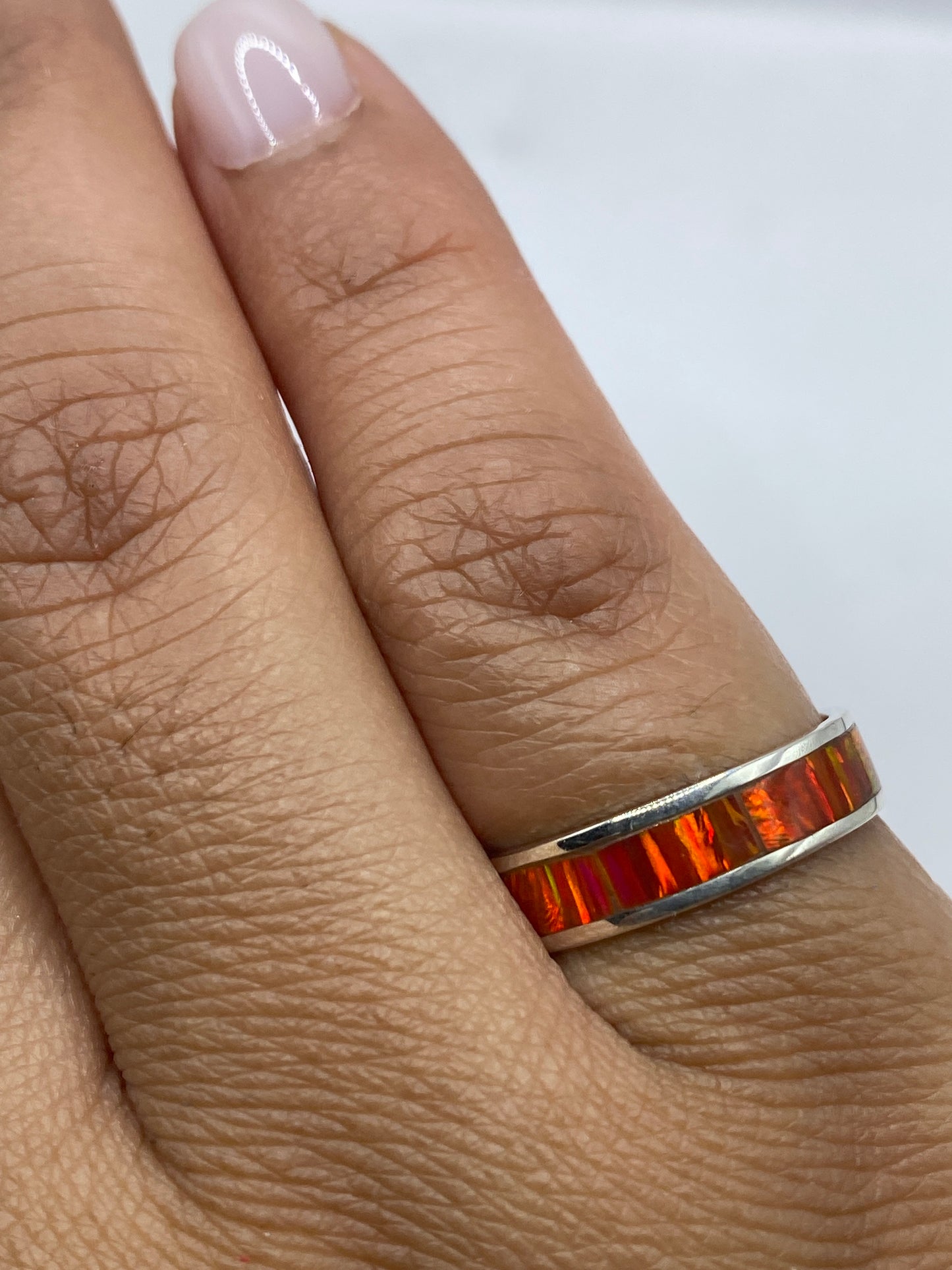 Anillo ópalo de fuego en la mano mostrando el brillo natural de la piedra