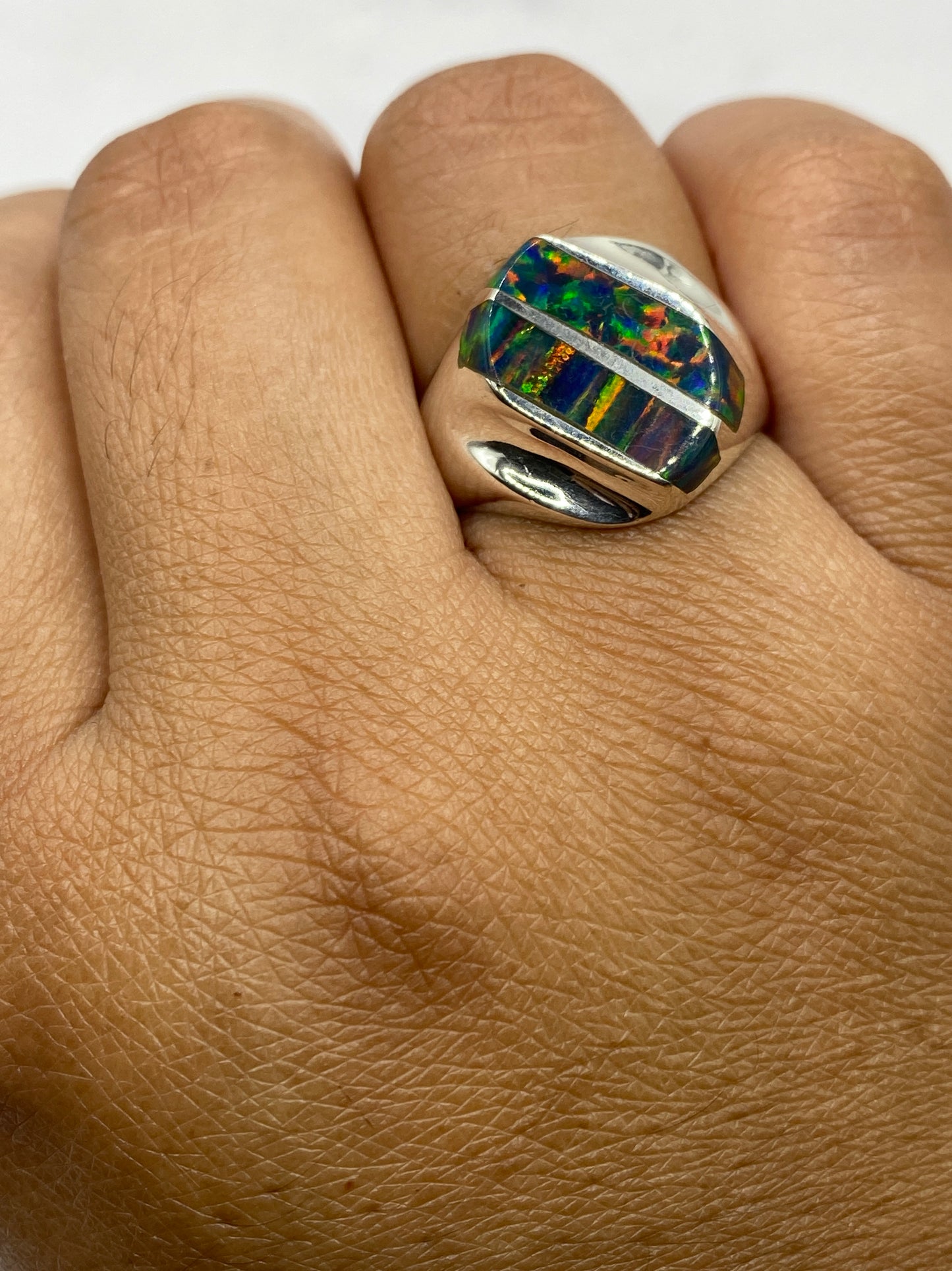 Anillo de ópalo de fuego sobre fondo blanco mostrando el sello 925 en la banda interna