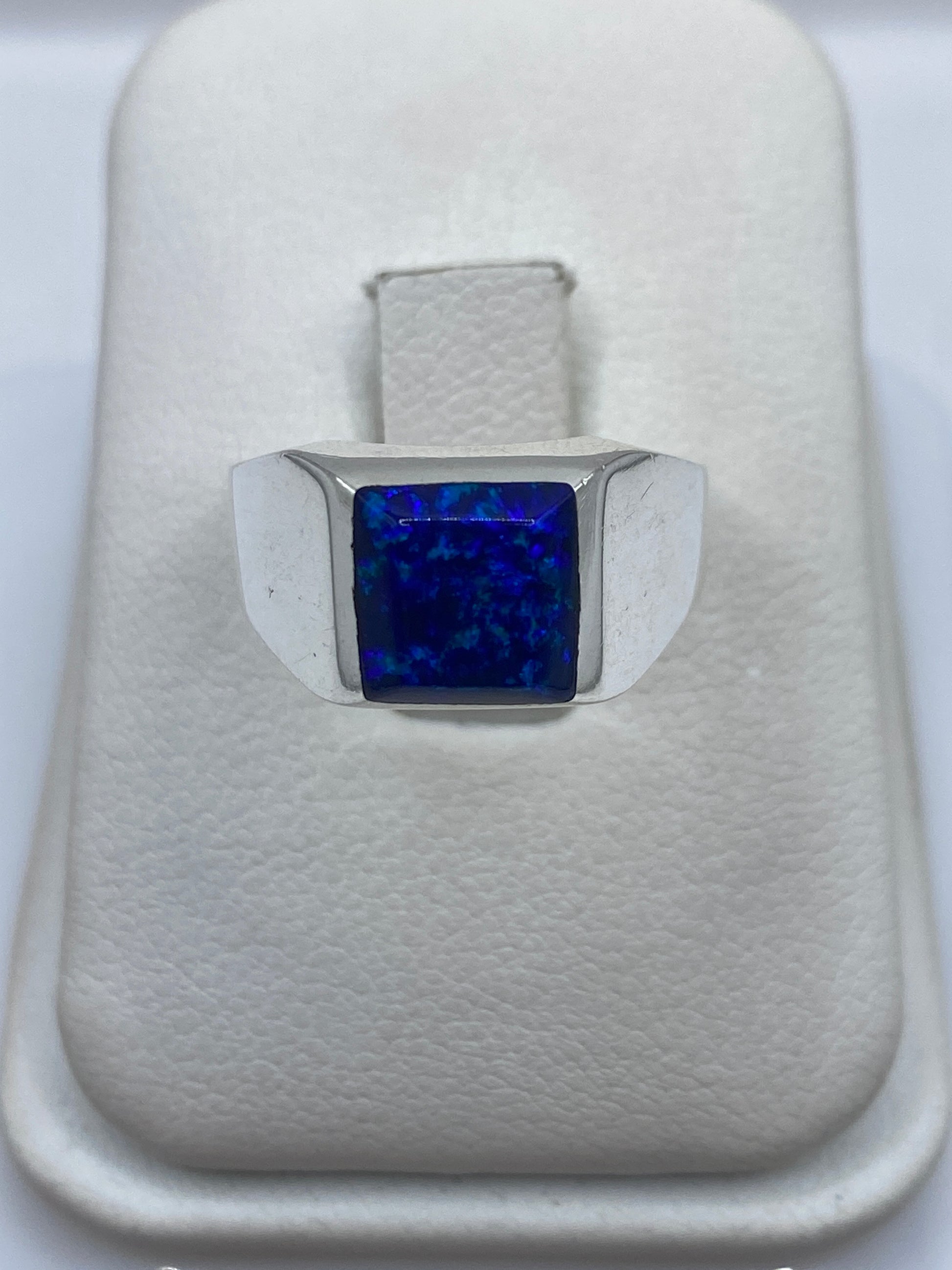 Anillo solitario de plata 950 con ópalo de fuego azul natural, visto desde arriba en la mano