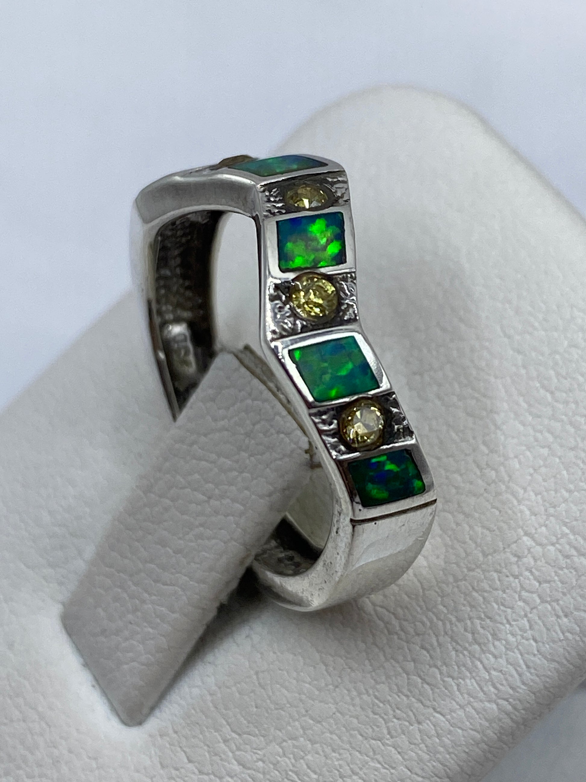 Detalle lateral del anillo de plata con texturas artesanales y ópalo de fuego