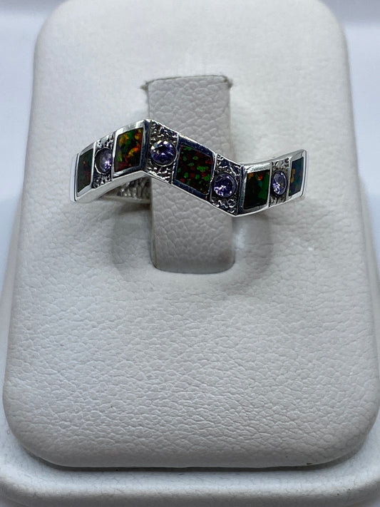 Anillo de plata .950 con ópalo de fuego multicolor en vista frontal sobre dedo