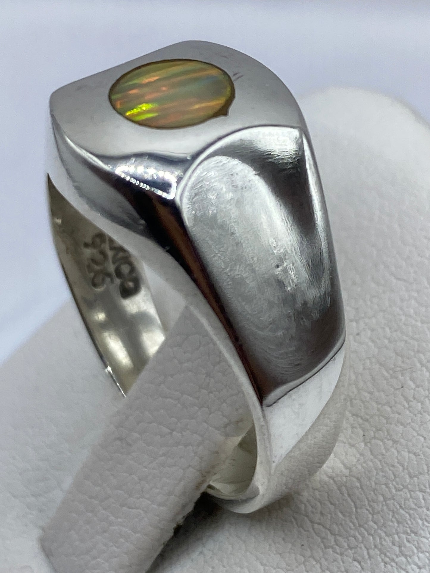 Detalle del ópalo de fuego con bandas de color rojo, naranja y verde en engaste de plata