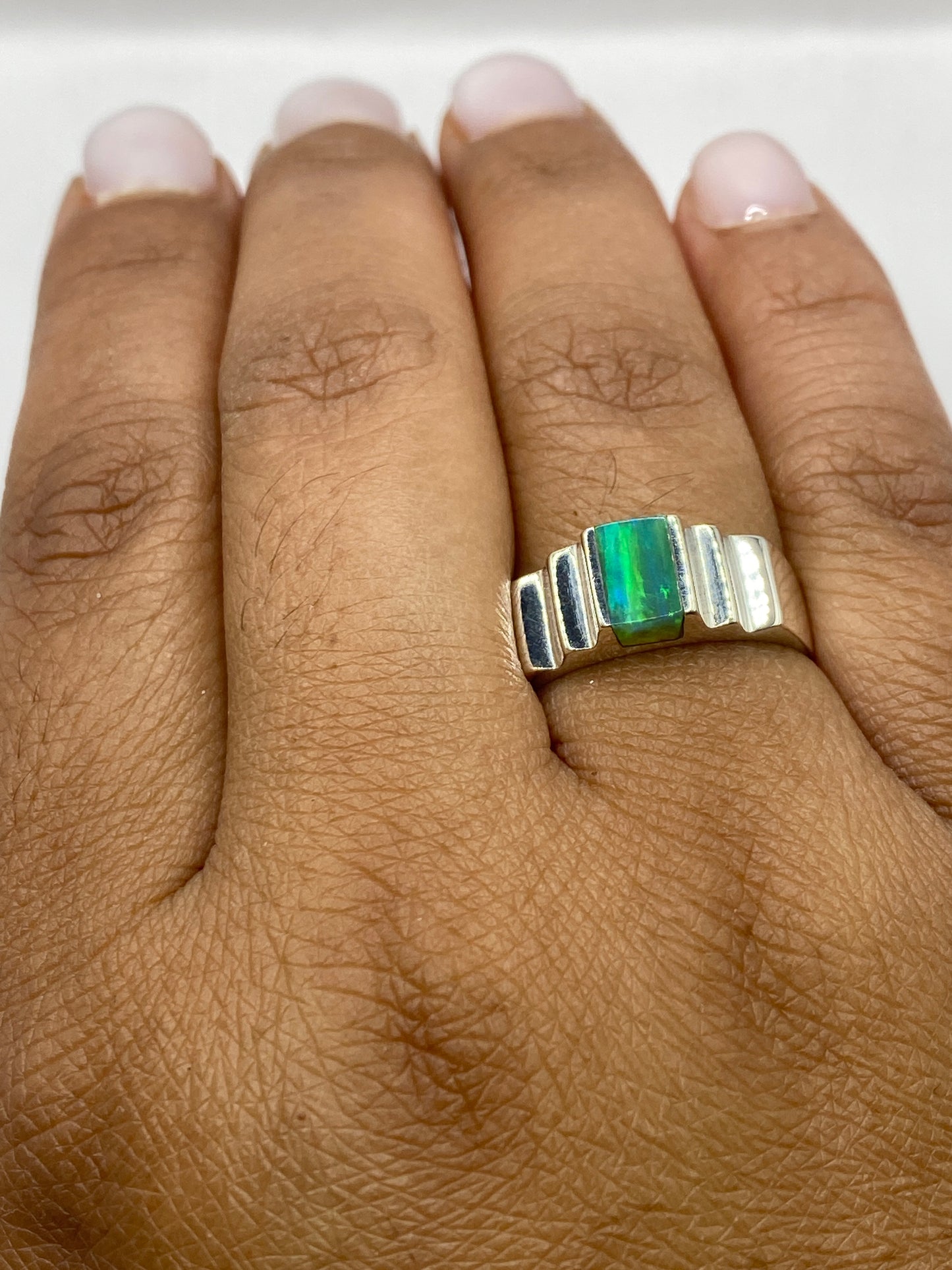 Anillo en dedo mostrando la profundidad del color verde y el fuego natural del ópalo