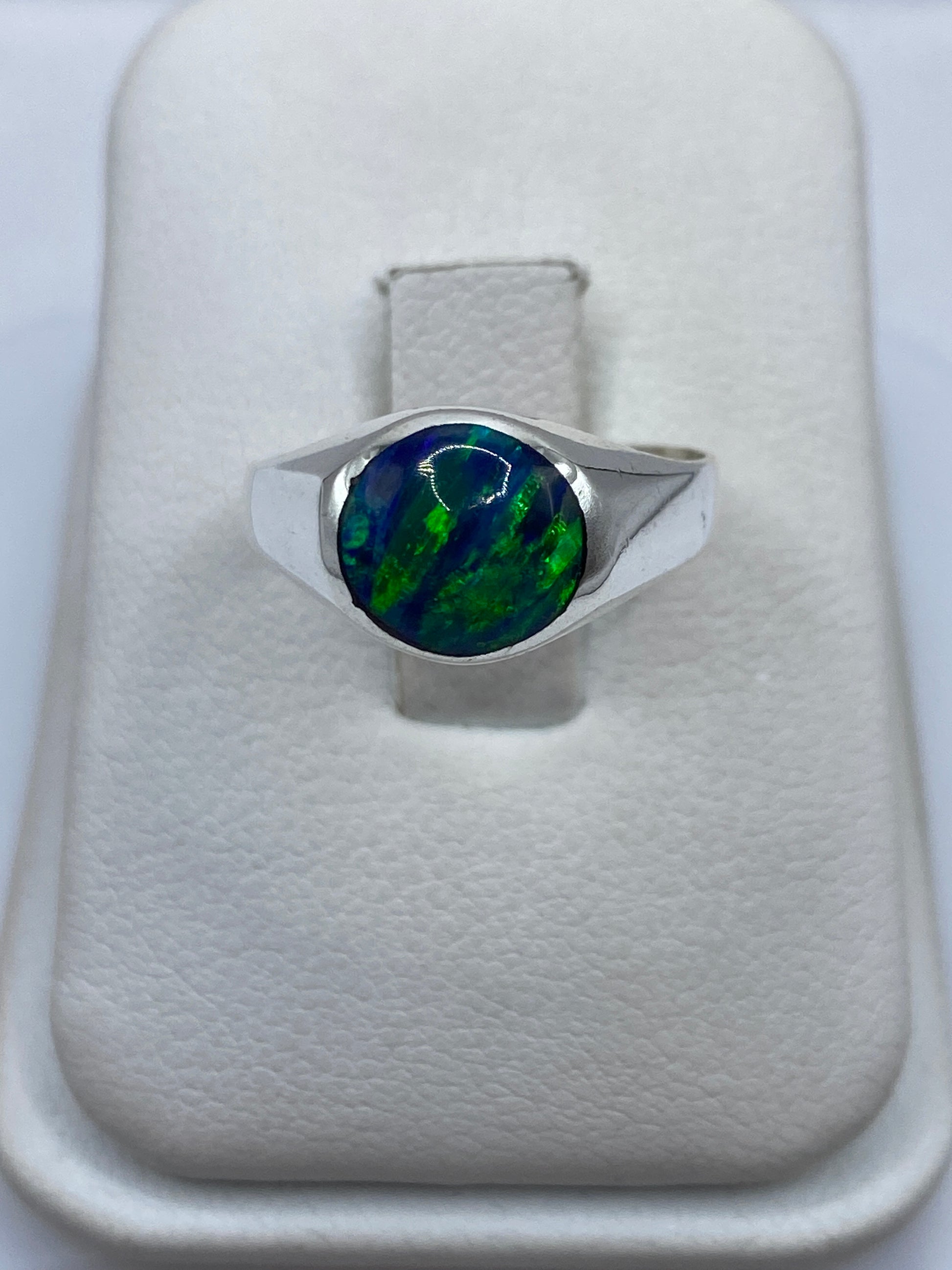 Anillo de plata .925 con ópalo de fuego azul sobre dedo, mostrando el juego de luz cromático