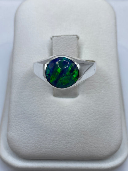Anillo de plata .925 con ópalo de fuego azul sobre dedo, mostrando el juego de luz cromático