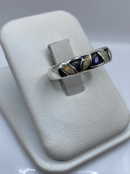Detalle frontal del anillo ópalo mostrando juego de colores rojo, naranja y amarillo