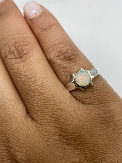 Anillo ópalo de fuego en mano mostrando brillo y movimiento de la piedra natural