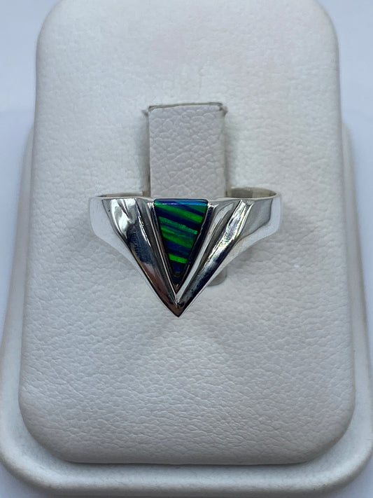 Anillo de plata triangular con piedra multicolor azul y verde en mano de mujer