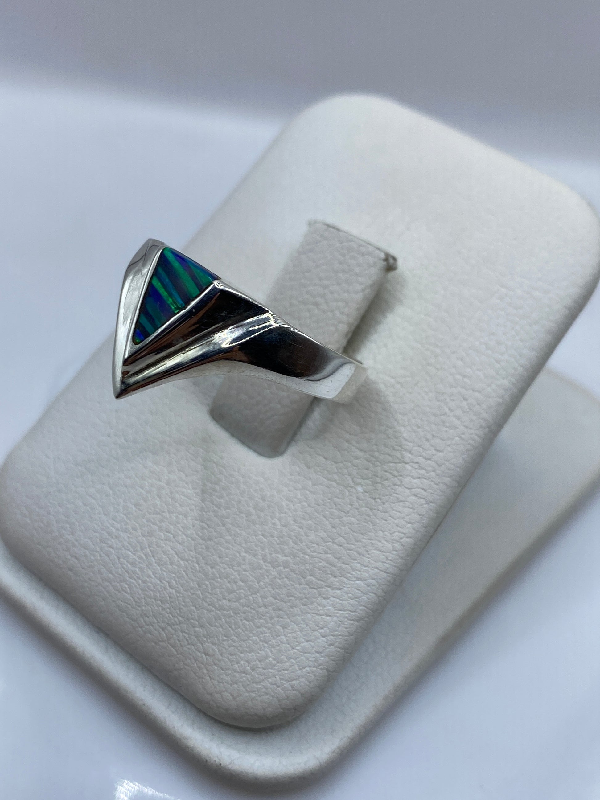 Vista frontal del anillo de plata con triángulo de piedra multicolor en tonos profundos