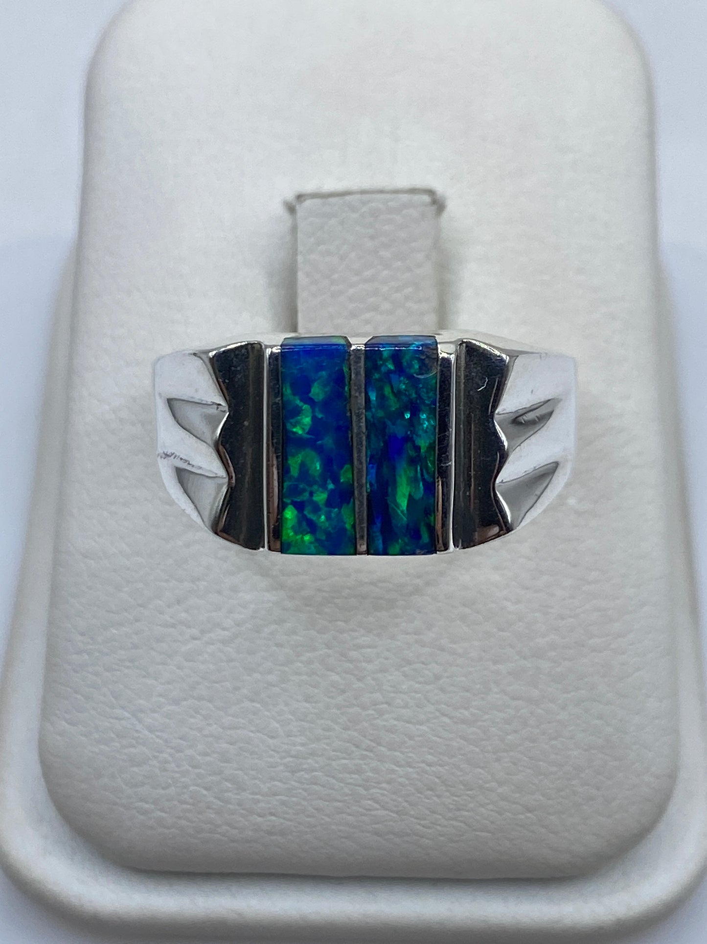 Anillo de plata con ópalo de fuego azul en diseño geométrico sobre dedo de hombre