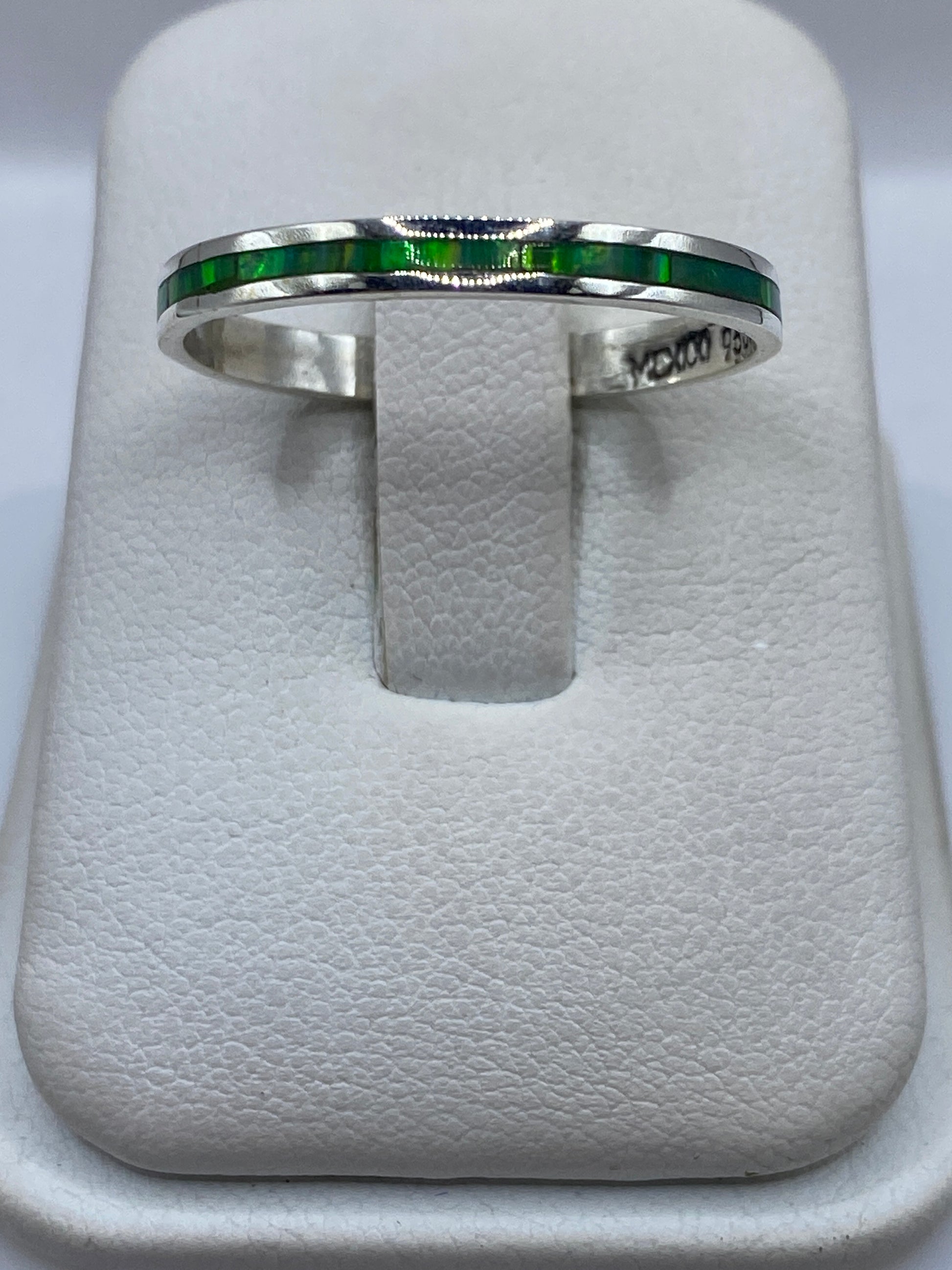 Anillo de plata .950 con ópalo de fuego verde limón, vista frontal sobre anillo de presentación blanco