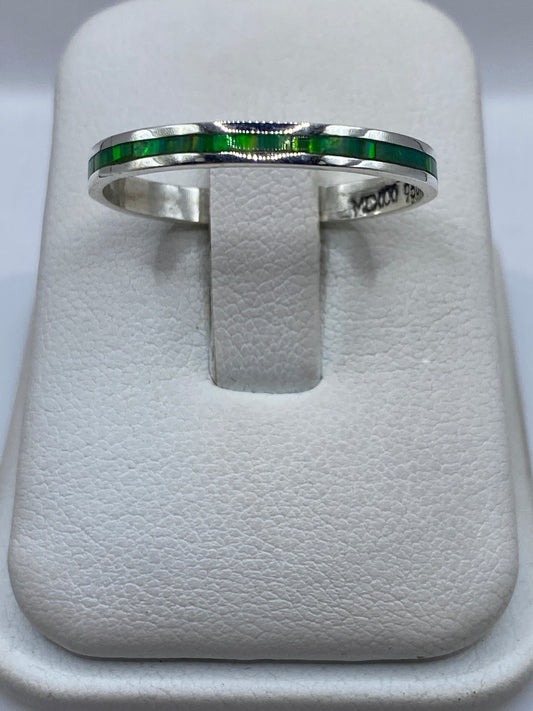 Anillo de plata .950 con ópalo de fuego verde limón, vista frontal sobre anillo de presentación blanco
