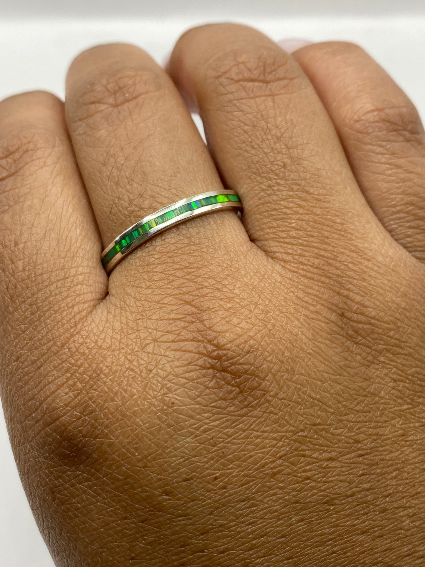 Anillo en mano mostrando el perfil delgado y elegante de la banda de plata pura