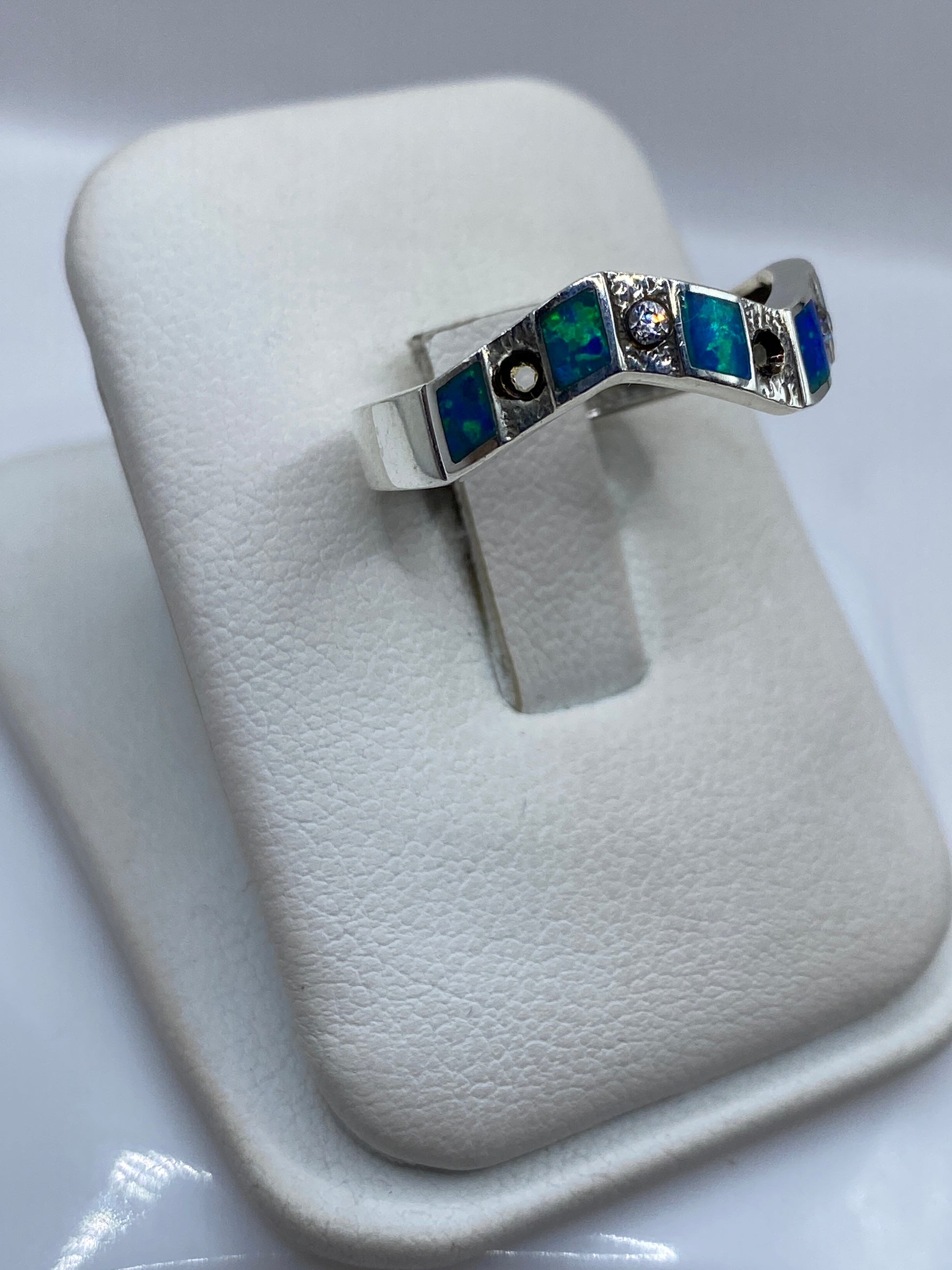 Vista lateral del anillo minimalista en plata .950 mostrando el engaste del ópalo azul