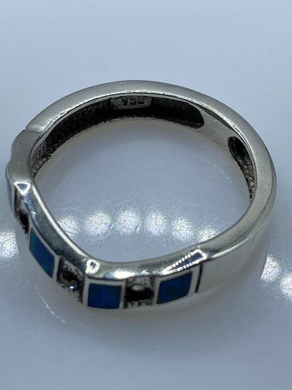 Anillo de plata .950 en dedo de mujer mostrando destellos azules del ópalo natural