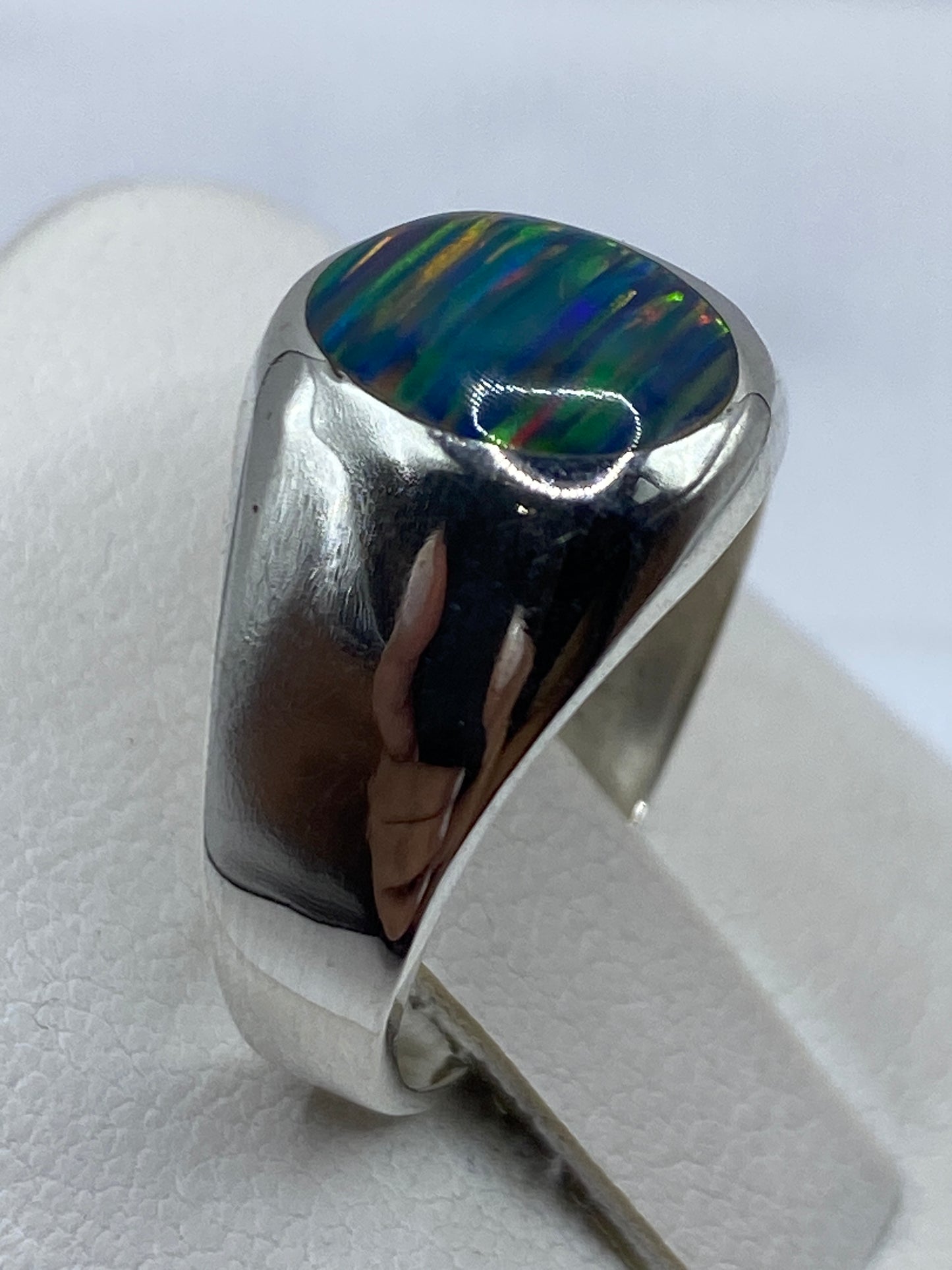 Anillo en la mano mostrando el brillo y profundidad del ópalo de fuego natural