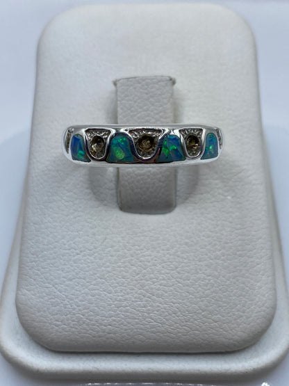 Anillo de plata .950 con ópalo de fuego azul cielo, visto de frente en estuche blanco