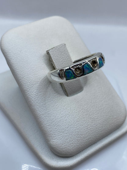 Detalle lateral del anillo con ópalo natural mostrando juego de colores azul y verde