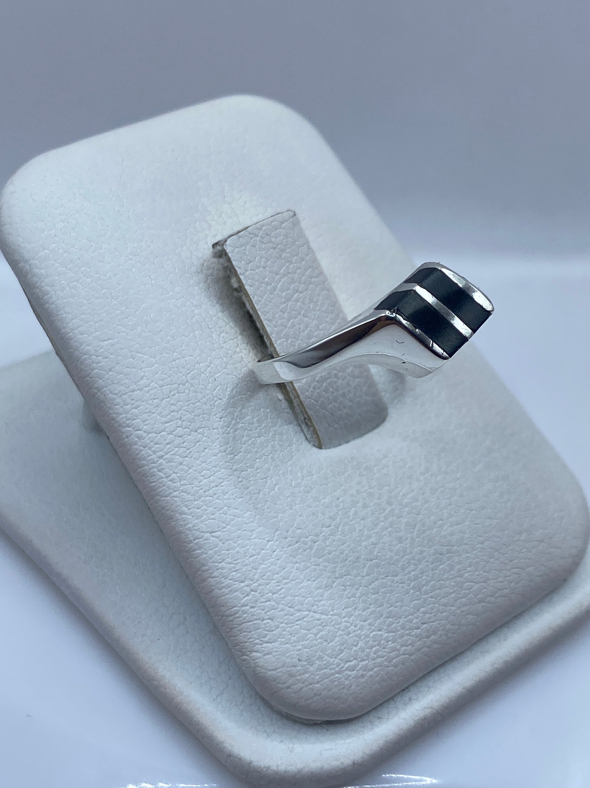 Detalle de la banda lisa de plata y la piedra ónix brillante