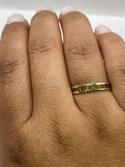 Anillo sobre dedo mostrando el brillo y juego de colores del ópalo de fuego