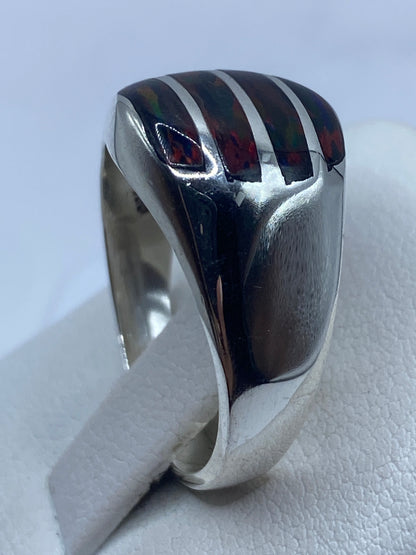 Anillo sobre dedo mostrando los colores del ópalo de fuego en luz natural