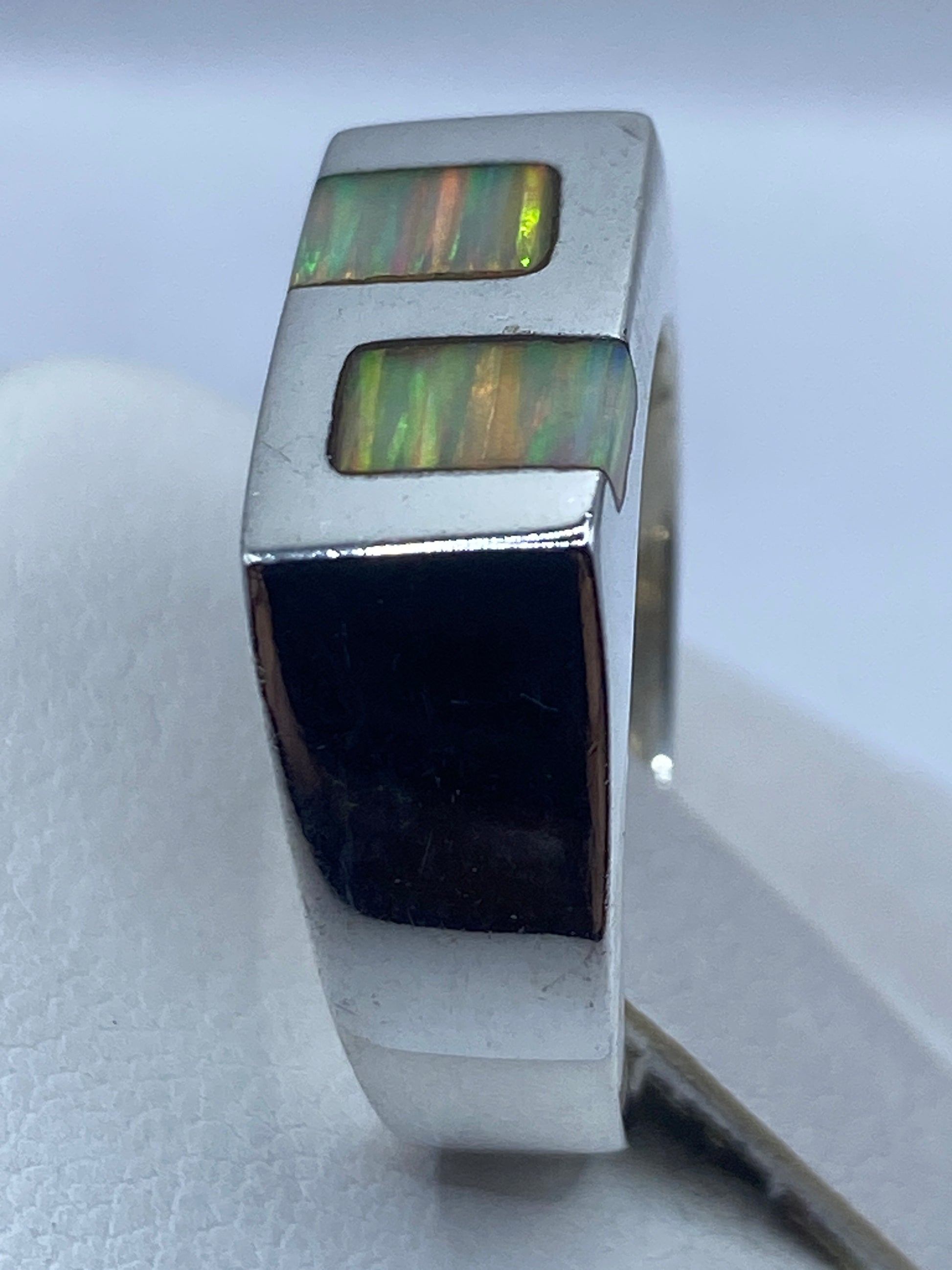 Anillo de ópalo de fuego en mano mostrando los colores naturales de la piedra en luz natural