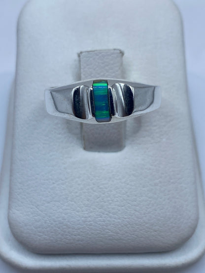 Anillo de plata con ópalo de fuego azul en diseño geométrico moderno sobre estuche blanco