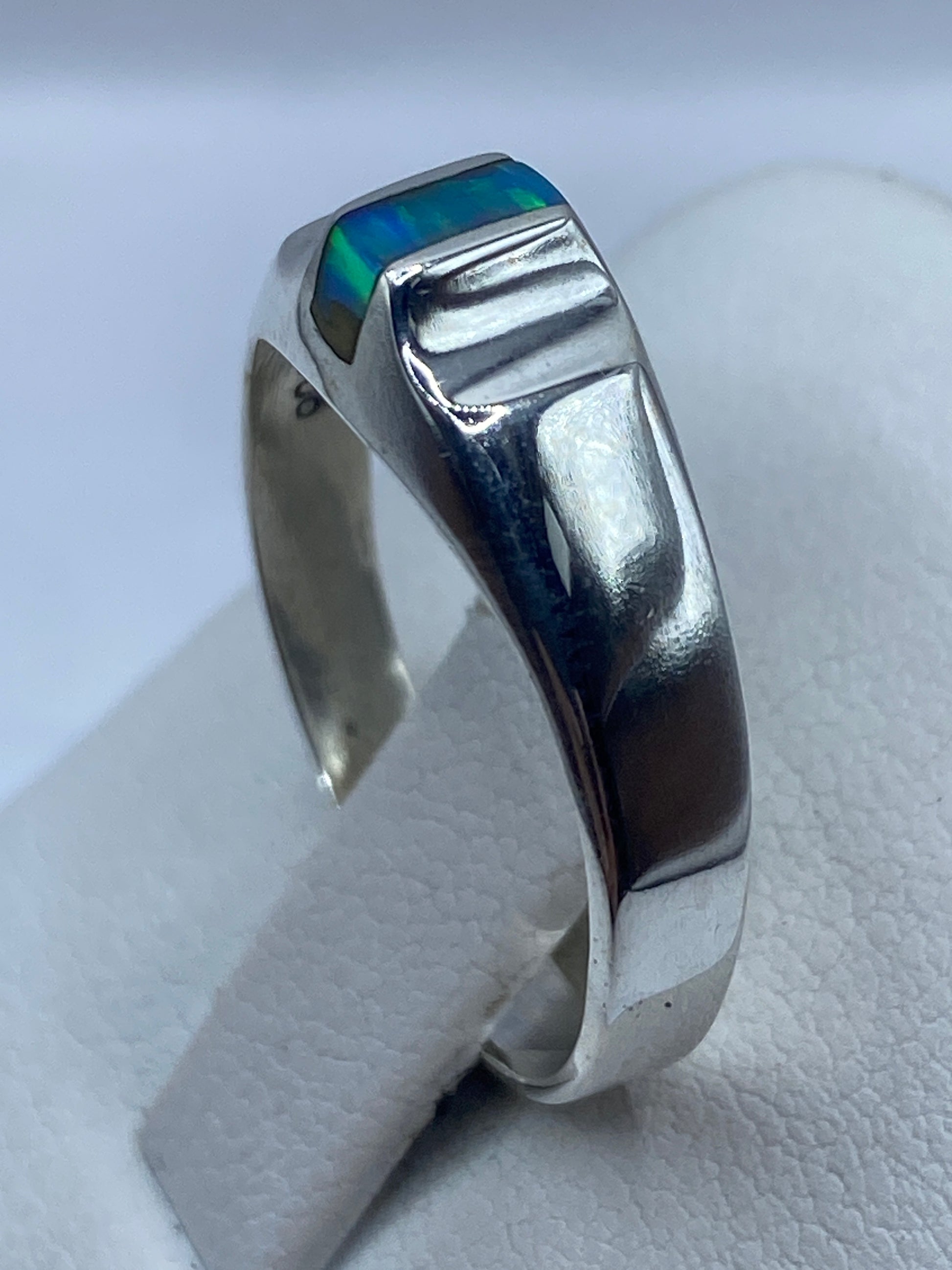 Ópalo de fuego azul engastado en anillo de plata .925, mostrando el juego de luz