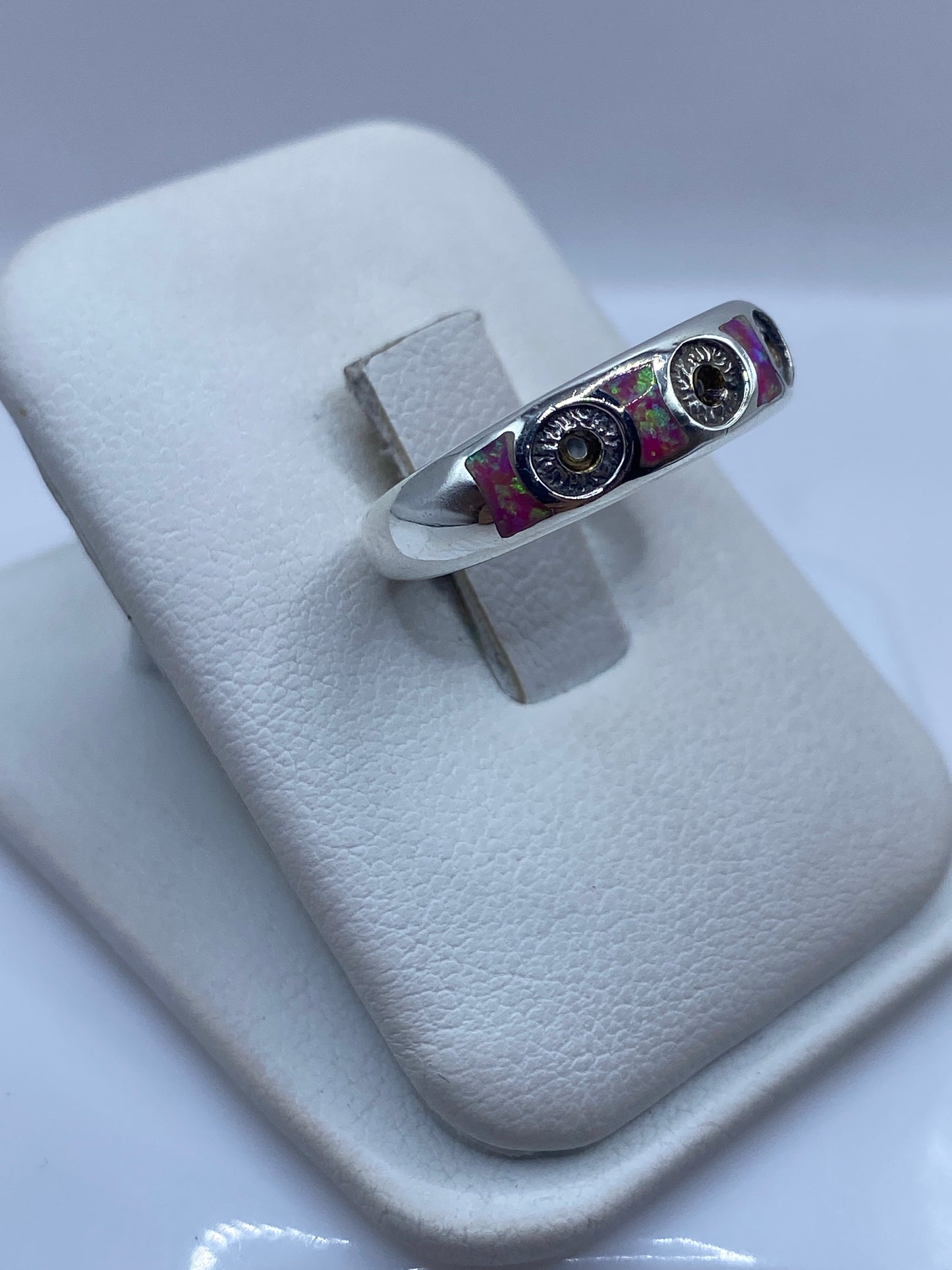 Vista lateral del anillo de plata con ópalo rosa mostrando el engaste artesanal