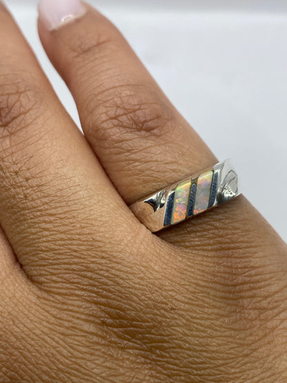 Anillo en la mano mostrando el sello de plata .950 y el brillo del ópalo