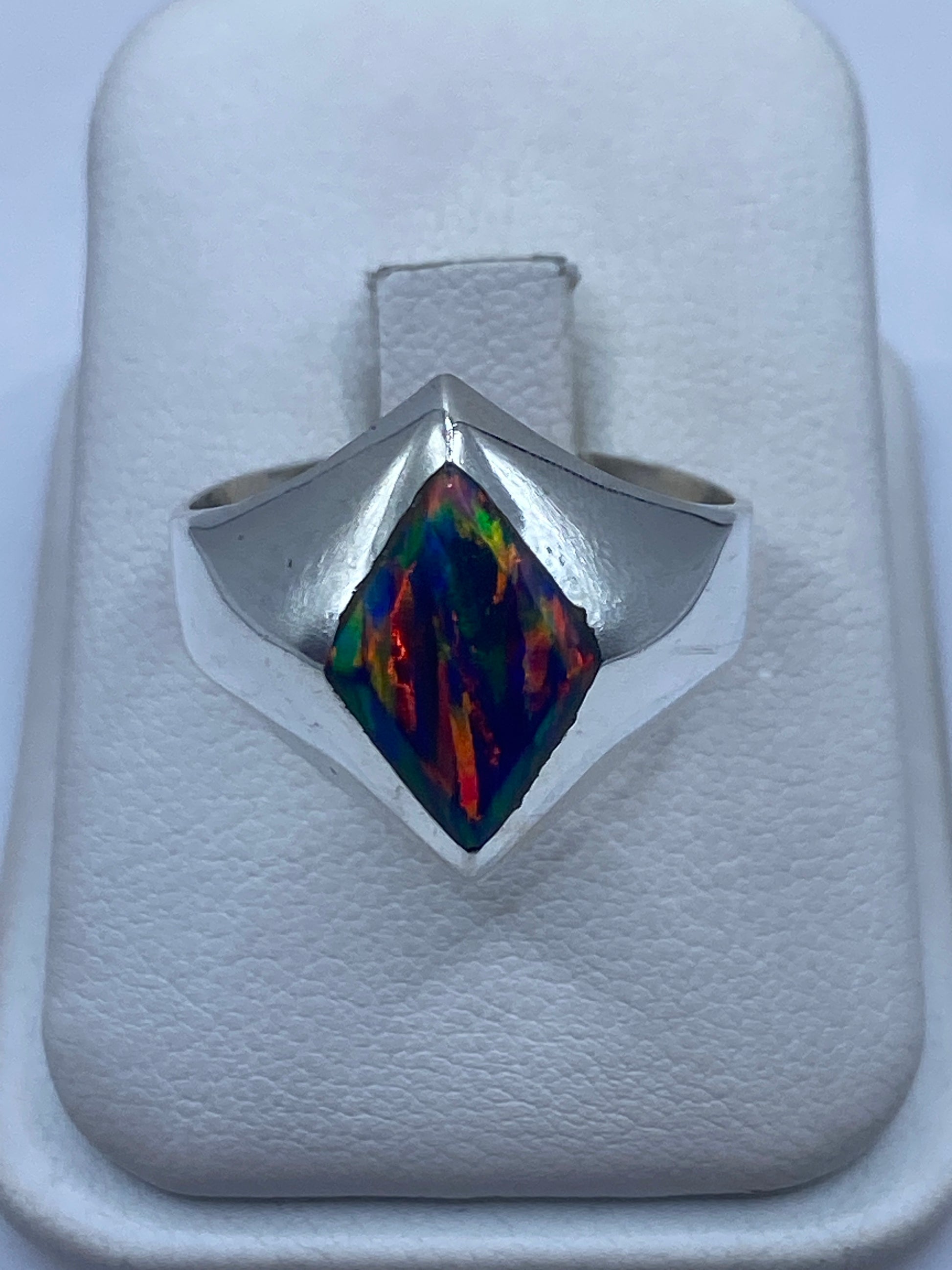 Anillo de plata signet con ópalo de fuego azul mostrando juego de colores único