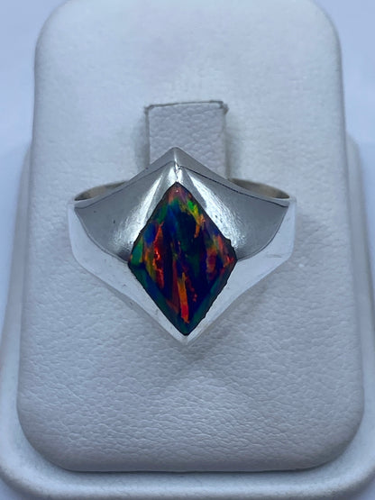 Anillo de plata signet con ópalo de fuego azul mostrando juego de colores único