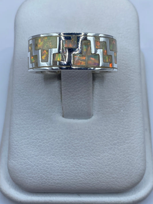 Anillo de plata .950 con ópalo de fuego natural mostrando juego cromático verde, naranja y rojo en luz natural